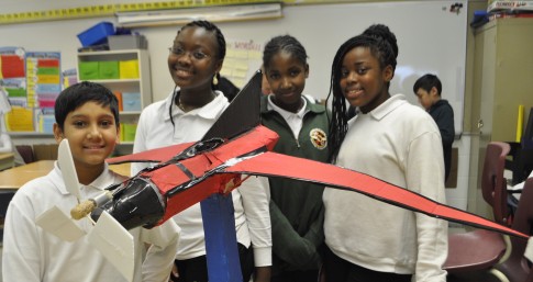 Happy youth with the wind turbine they designed and built as part of TREC Education's Renewable Energy Design Challenge Program